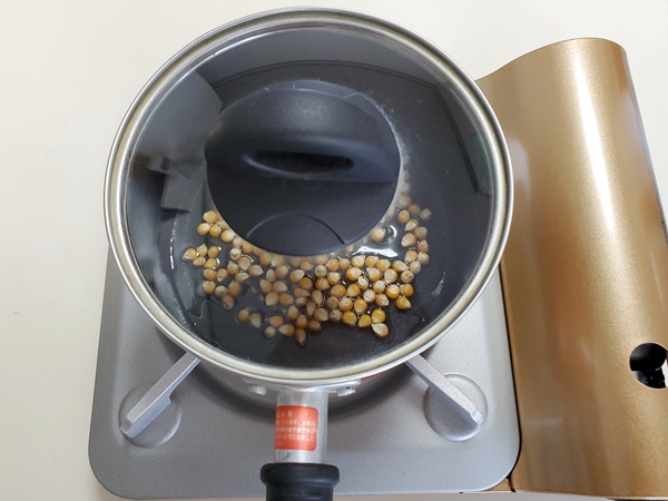ポップコーン豆を入れた片手鍋にフタをした画像です。
