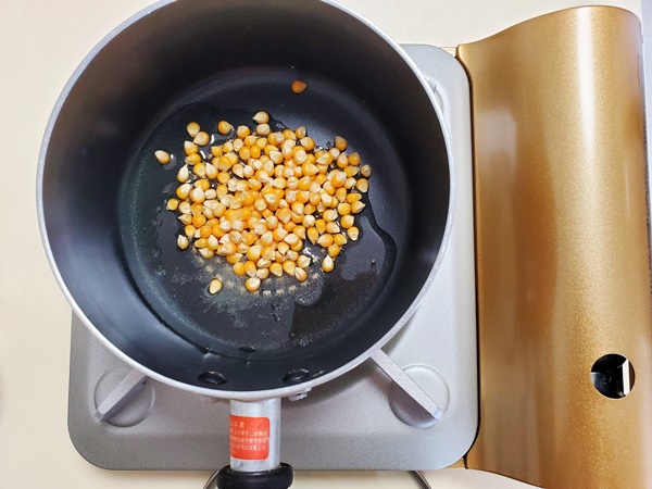 深めの片手鍋にポップコーン豆、サラダ油、塩が入っている画像です。