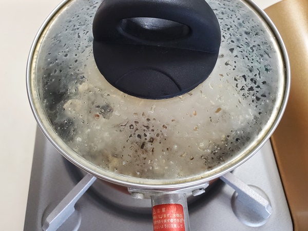フタをして中火で加熱したポップコーン豆が、鍋の中で弾けている画像です。
