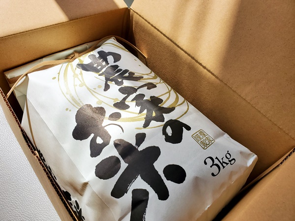 茨城県産コシヒカリ米を段ボール箱に詰めて発送する場面の画像です。